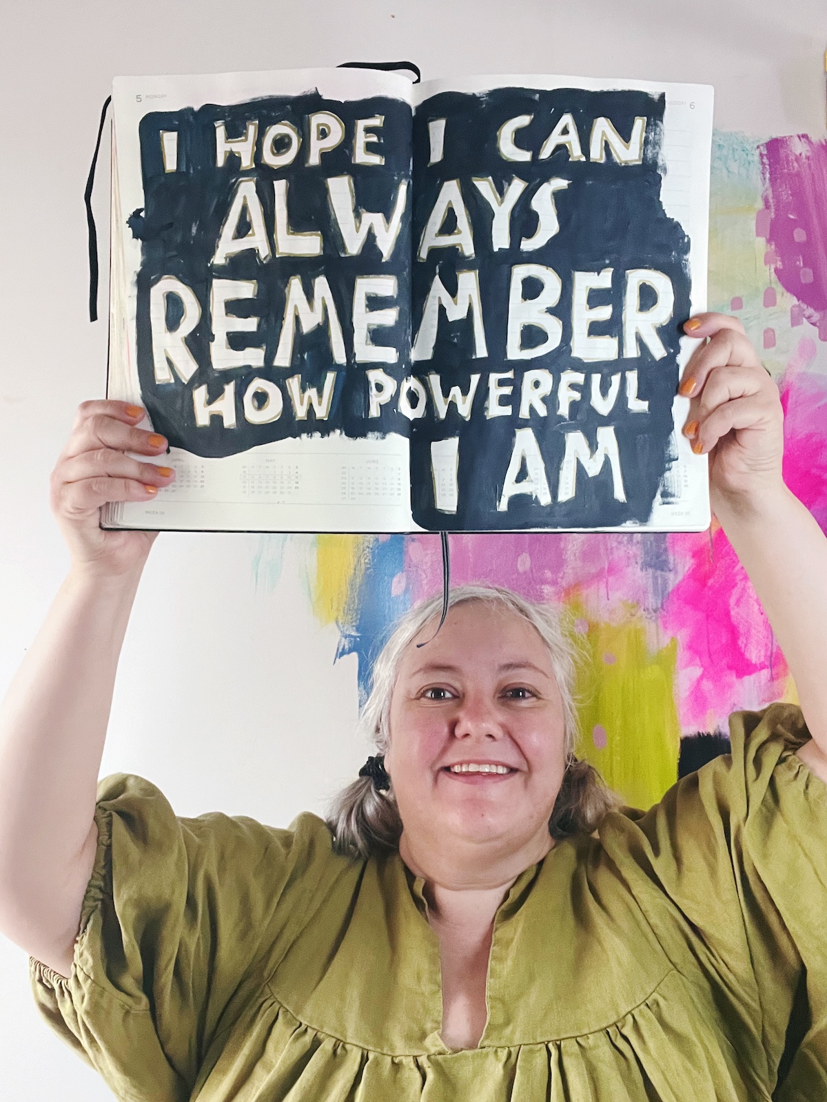 Me holding up my journal that says: I hope I can always remember how powerful I am.